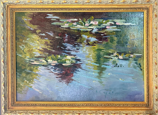 A framed impressionist oil painting , Monet's Waterlilies 1, depicting water lilies in Monet's Garden , housed in ornate French gold frame. The painting features blue water, green and yellow reflections, and pink and white lily pads, with a signature in the lower right corner.